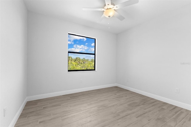 empty room with light wood finished floors, baseboards, and a ceiling fan