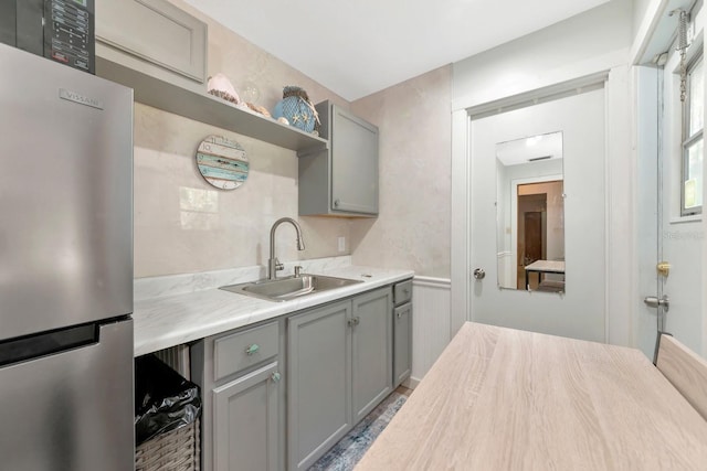 2070 59th St, Sarasota, FL 34243 - kitchen with freestanding refrigerator, gray cabinets, light countertops, and open shelves