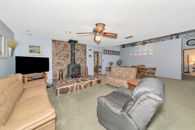2070 59th St, Sarasota, FL 34243 - living area with carpet, a wood stove, ceiling fan, and a textured ceiling