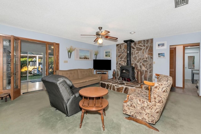 2070 59th St, Sarasota, FL 34243 - carpeted living room featuring a wood stove, ceiling fan, and a textured ceiling