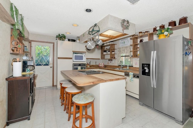2070 59th St, Sarasota, FL 34243 - kitchen featuring appliances with stainless steel finishes, wooden counters, open shelves, light flooring, and recessed lighting