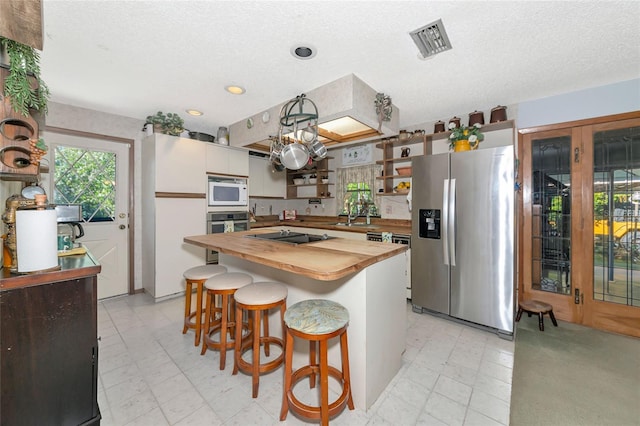 2070 59th St, Sarasota, FL 34243 - kitchen featuring stainless steel appliances, butcher block counters, open shelves, healthy amount of natural light, and recessed lighting