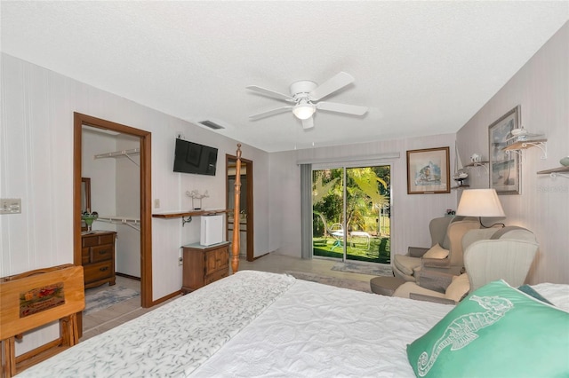 2070 59th St, Sarasota, FL 34243 - bedroom featuring access to exterior, a spacious closet, a textured ceiling, a closet, and ceiling fan