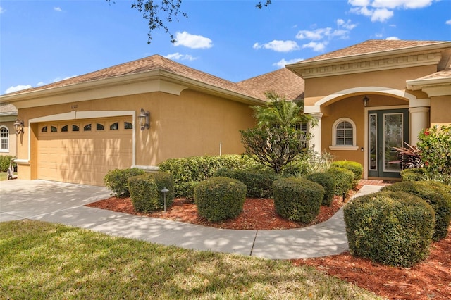 12211 Aster Ave, Bradenton, FL 34212 - view of front of home featuring a shingled roof, concrete driveway, an attached garage, and stucco siding