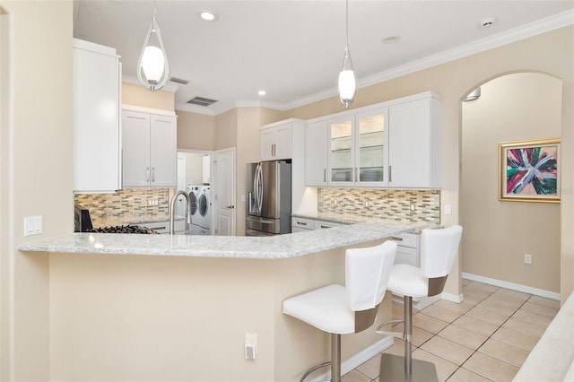 12211 Aster Ave, Bradenton, FL 34212 - kitchen with a breakfast bar, independent washer and dryer, ornamental molding, stainless steel fridge, and light tile patterned flooring