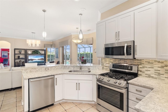 12211 Aster Ave, Bradenton, FL 34212 - kitchen with tasteful backsplash, open floor plan, stainless steel appliances, a peninsula, and crown molding