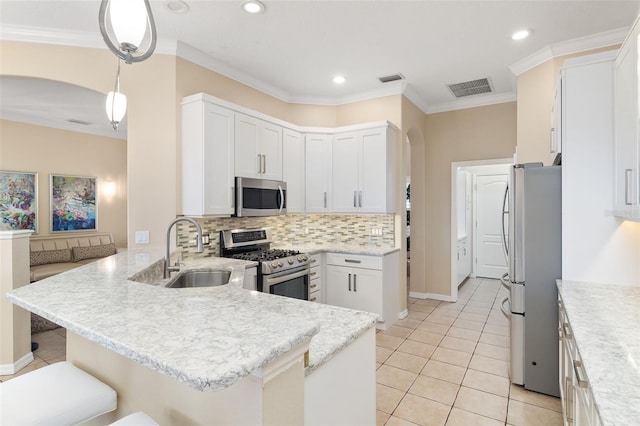 12211 Aster Ave, Bradenton, FL 34212 - kitchen with a peninsula, arched walkways, a sink, appliances with stainless steel finishes, and tasteful backsplash