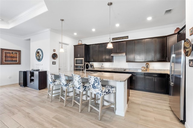 25325 Longmeadow Dr, Punta Gorda, FL 33955 - kitchen featuring visible vents, light wood-style flooring, a sink, appliances with stainless steel finishes, and a breakfast bar area