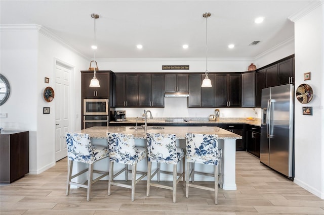 25325 Longmeadow Dr, Punta Gorda, FL 33955 - kitchen with light stone countertops, under cabinet range hood, light wood-style floors, stainless steel appliances, and a sink