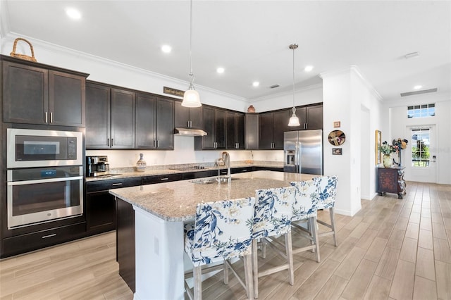 25325 Longmeadow Dr, Punta Gorda, FL 33955 - kitchen featuring appliances with stainless steel finishes, a breakfast bar area, light wood-type flooring, and a sink