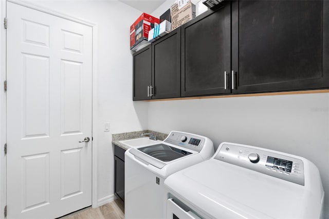 25325 Longmeadow Dr, Punta Gorda, FL 33955 - washroom featuring washing machine and clothes dryer, baseboards, light wood-style flooring, cabinet space, and a sink