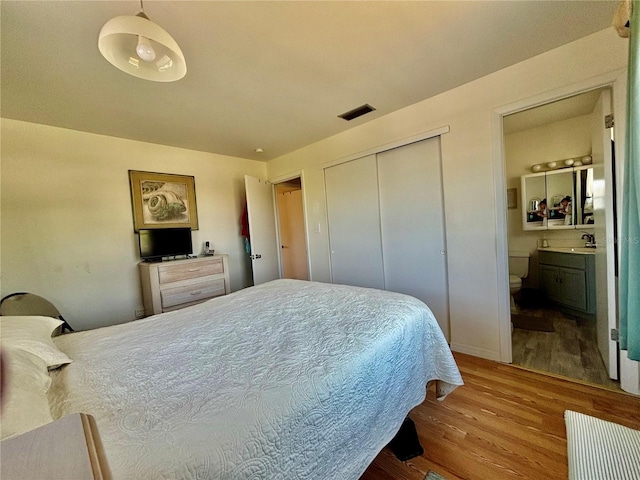 1633 Leisure Dr Unit M-37, Bradenton, FL 34207 - bedroom featuring visible vents, connected bathroom, wood finished floors, a closet, and a sink