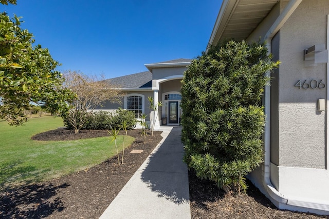 4606 Lake Fox Pl, Parrish, FL 34219 - entrance to property with stucco siding, a yard, and a shingled roof