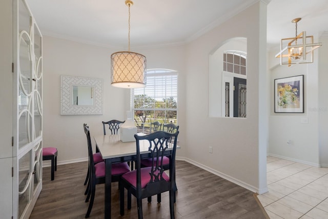 4606 Lake Fox Pl, Parrish, FL 34219 - dining room with a chandelier, wood finished floors, ornamental molding, baseboards, and arched walkways