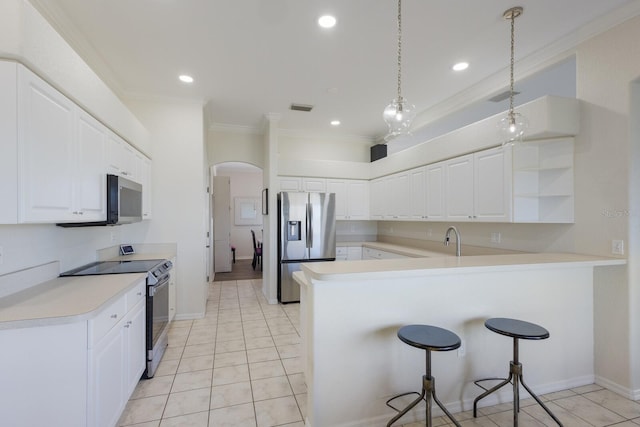 4606 Lake Fox Pl, Parrish, FL 34219 - kitchen with appliances with stainless steel finishes, crown molding, a peninsula, arched walkways, and a kitchen breakfast bar