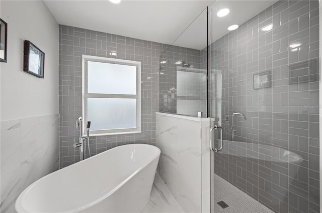 1647 Siesta Dr, Sarasota, FL 34239 - bathroom with tile walls, a soaking tub, a shower stall, recessed lighting, and marble finish flooring
