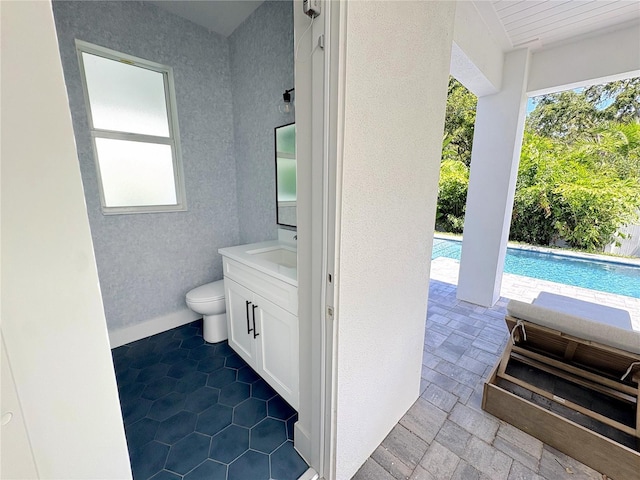 1647 Siesta Dr, Sarasota, FL 34239 - bathroom with vanity, healthy amount of natural light, a textured wall, and toilet