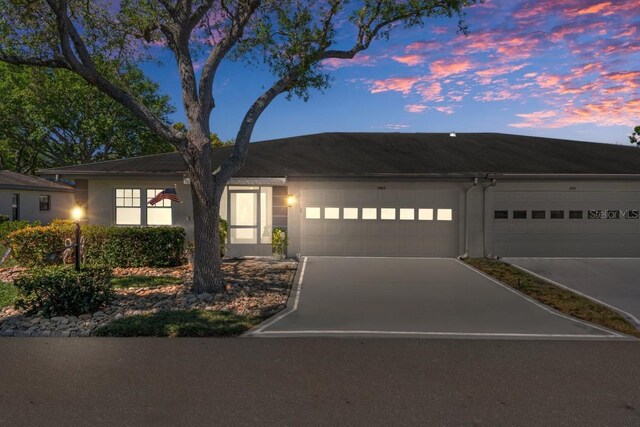 view of front facade with concrete driveway, a garage, and stucco siding