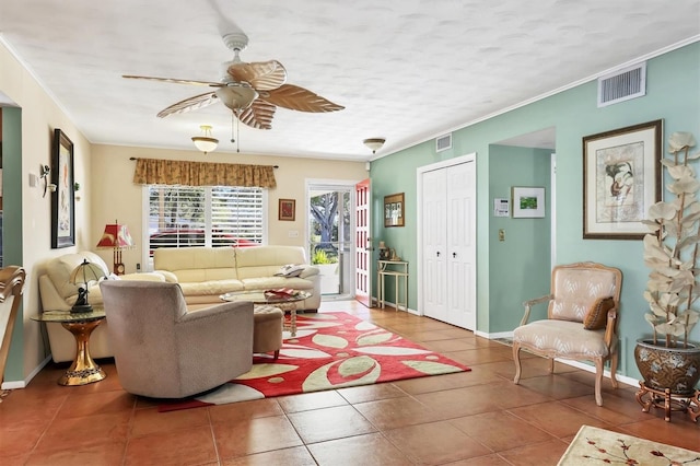 tiled living area with baseboards, ceiling fan, visible vents, and crown molding