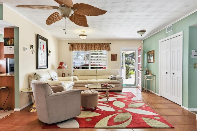 living room featuring tile patterned floors, visible vents, ornamental molding, and a ceiling fan