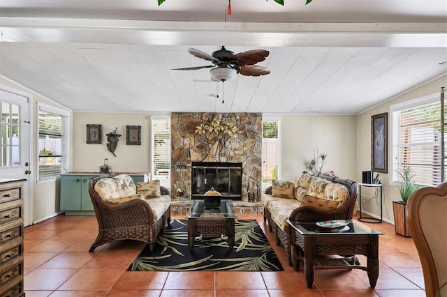 living area featuring a ceiling fan, light tile patterned floors, lofted ceiling, and a fireplace
