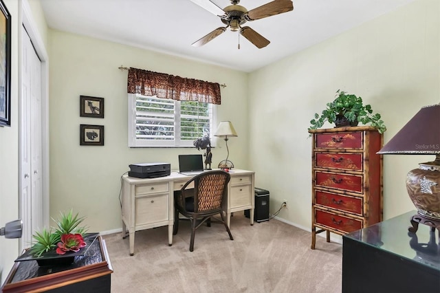 home office featuring light colored carpet, baseboards, and a ceiling fan