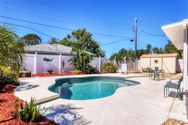 view of swimming pool with a fenced backyard, an outdoor structure, a patio area, and a fenced in pool