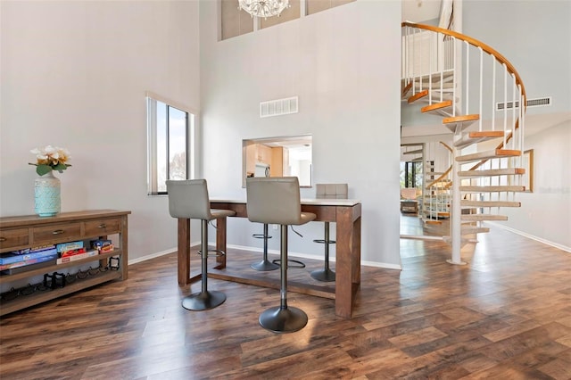 6263 Midnight Pass Rd Unit 301, Sarasota, FL 34242 - dining room with a towering ceiling, stairs, wood finished floors, baseboards, and healthy amount of natural light