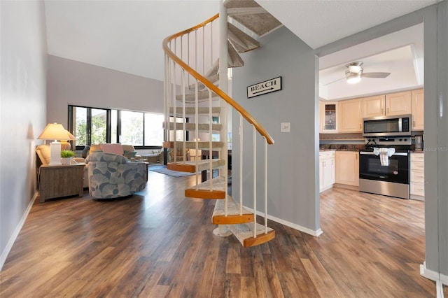 6263 Midnight Pass Rd Unit 301, Sarasota, FL 34242 - staircase featuring wood finished floors, baseboards, a ceiling fan, and a towering ceiling