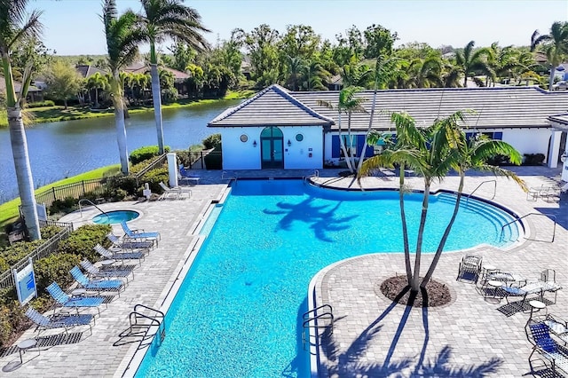 pool featuring a water view, fence, and a patio area