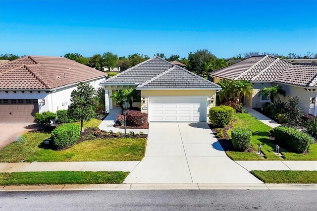 ranch-style house with stucco siding, driveway, a tile roof, and a garage