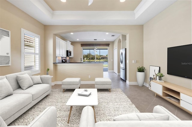 living room featuring recessed lighting, a raised ceiling, and light tile patterned floors