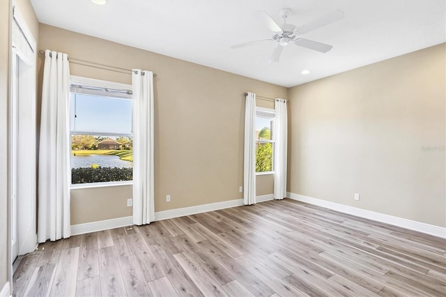 empty room featuring baseboards, recessed lighting, light wood-style flooring, and ceiling fan