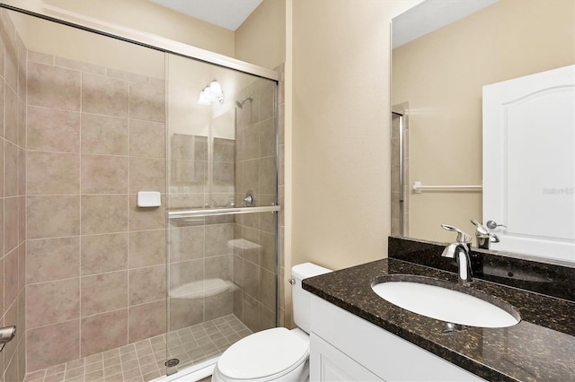 full bathroom featuring toilet, a shower stall, and vanity