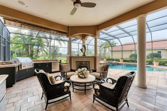 view of patio with a grill, an outdoor kitchen, ceiling fan, a glass covered fireplace, and a lanai