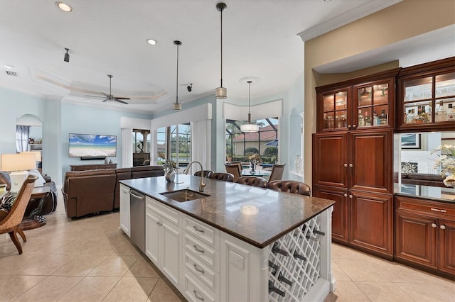 kitchen featuring a sink, light tile patterned floors, a raised ceiling, and crown molding