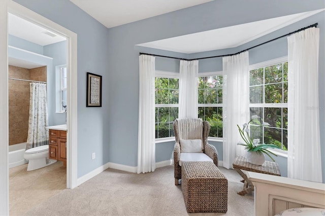 living area featuring light tile patterned floors, baseboards, and light carpet