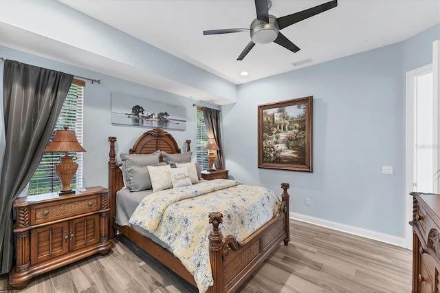 bedroom featuring light wood-style flooring, baseboards, and multiple windows