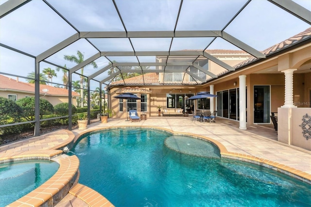 view of pool with a patio area, a pool with connected hot tub, and a lanai