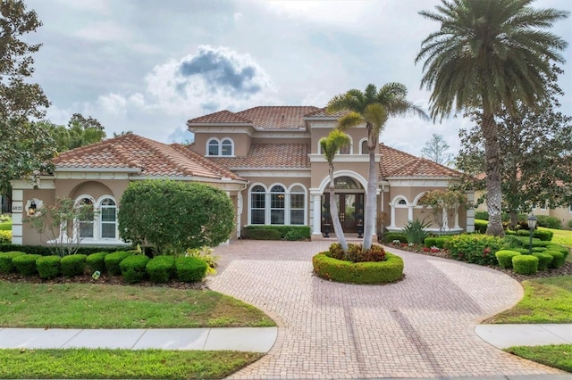 6822 Dominion Ln, Lakewood Ranch, FL 34202 - mediterranean / spanish-style house with curved driveway, stucco siding, and french doors