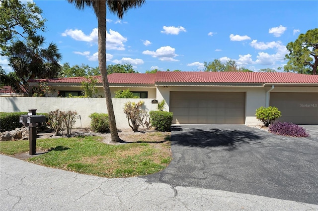 3804 Sun Eagle Ln, Bradenton, FL 34210 - view of front of home featuring stucco siding, fence, an attached garage, aphalt driveway, and a tiled roof