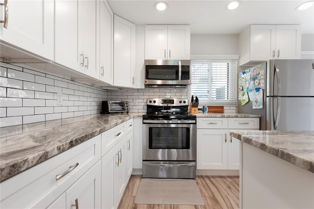 3804 Sun Eagle Ln, Bradenton, FL 34210 - kitchen with white cabinetry, stainless steel appliances, and decorative backsplash