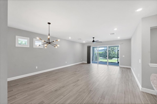 11717 Blue Hill Trl, Lakewood Ranch, FL 34211 - unfurnished room with visible vents, baseboards, recessed lighting, ceiling fan with notable chandelier, and wood finished floors