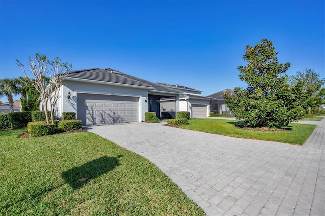 11717 Blue Hill Trl, Lakewood Ranch, FL 34211 - ranch-style house with an attached garage, stucco siding, a front lawn, a tiled roof, and decorative driveway