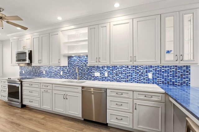 1928 Harbourside Dr Unit 1403, Longboat Key, FL 34228 - kitchen with stainless steel appliances, a sink, a ceiling fan, light wood-type flooring, and open shelves