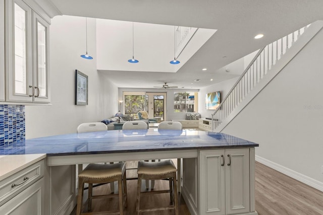 1928 Harbourside Dr Unit 1403, Longboat Key, FL 34228 - kitchen featuring a kitchen bar, decorative backsplash, ceiling fan, wood finished floors, and recessed lighting