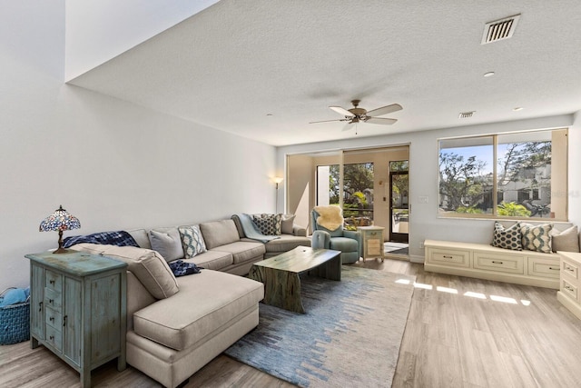 1928 Harbourside Dr Unit 1403, Longboat Key, FL 34228 - living room featuring light wood finished floors, a ceiling fan, plenty of natural light, and a textured ceiling