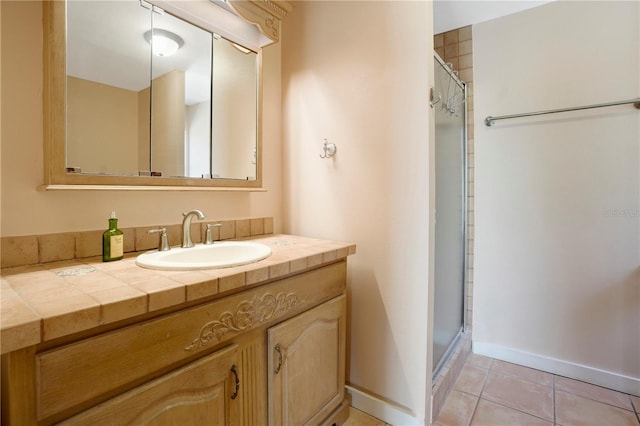 full bath with tile patterned flooring, a shower stall, vanity, and baseboards