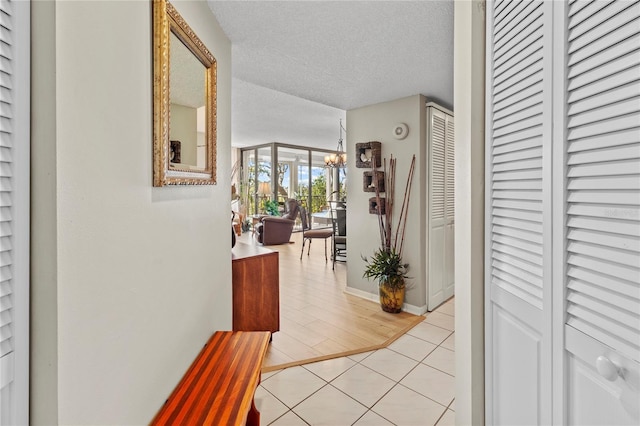 6269 Palma Del Mar Blvd S Unit 308, Saint Petersburg, FL 33715 - hall featuring light tile patterned flooring, a textured ceiling, and a chandelier
