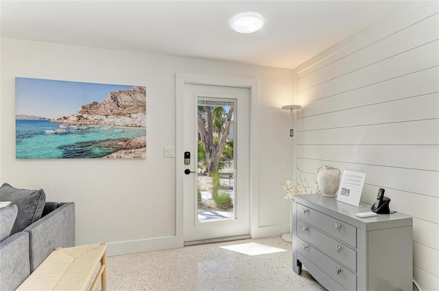 doorway featuring baseboards and speckled floor